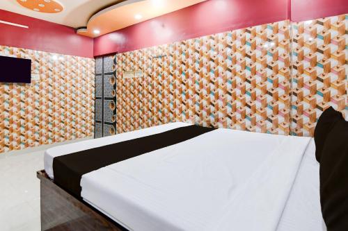 a bedroom with a bed and a wall at Hotel O Blue Star Hotel & Restaurant in Bārāsat