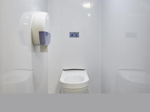 a white bathroom with a toilet and a phone at hotelF1 Poitiers Nord Futuroscope in Chasseneuil-du-Poitou