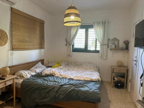 a bedroom with a bed and a chandelier at Tal Shahar Extension in Tal Shaẖar