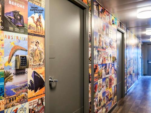 an open door in a hallway with posters on the walls at hotelF1 Les Ulis Courtaboeuf in Les Ulis