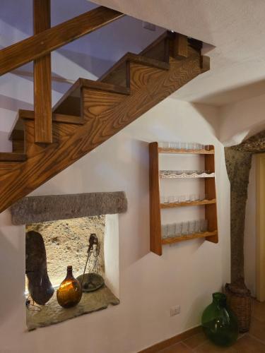 a room with wooden stairs and a shelf with vases at Domu Malaspina in Bosa