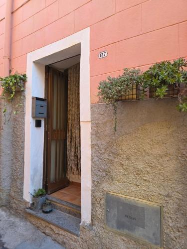 an entrance to a pink building with a door at Domu Malaspina in Bosa