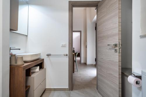 a bathroom with a sink and a glass shower door at Loft San Basilio in Palermo