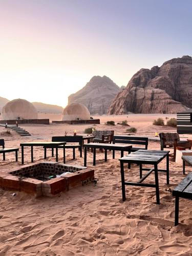 a group of picnic tables in the desert at Scarlet Luxury Camp Wadi Rum in Wadi Rum
