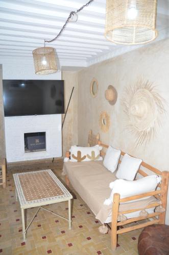 un salon avec un canapé et une télévision dans l'établissement Riad dar serenity, à Marrakech