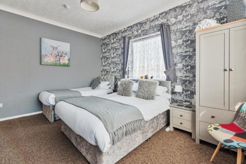 a bedroom with two beds and a window at Westbrook Lodge Guest House in Margate