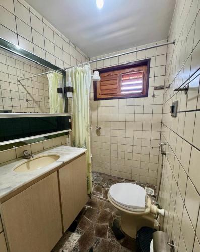 a bathroom with a toilet and a sink and a mirror at Villa Jaguaribe in Fortim