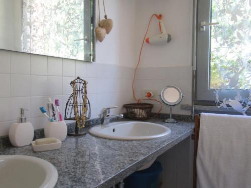 a bathroom counter with two sinks and a mirror at Casa Bella Vista- Punta Gaeta San Siro CO in San Siro