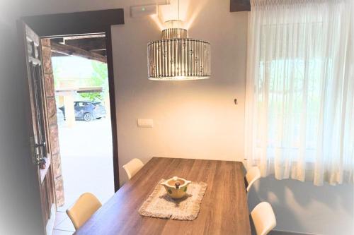 una sala da pranzo con tavolo in legno e lampadario di La Font, un bungalow cerca del mar, alegre y acogedor - La Font, Villa Sabrina Resort a El Perelló