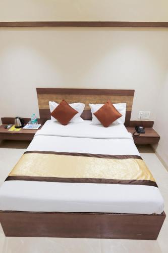 a bedroom with a large bed with brown pillows at Hotel Laxmi Palace in Shirdi