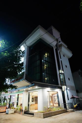 a large building with a large window at night at Hotel Laxmi Palace in Shirdi