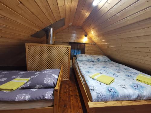 a bedroom with two beds in a wooden cabin at Ainja Puhkemaja in Viljandi