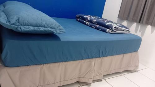 - un lit bleu avec 2 oreillers au-dessus dans l'établissement Próximo das 42 Praias, à Florianópolis
