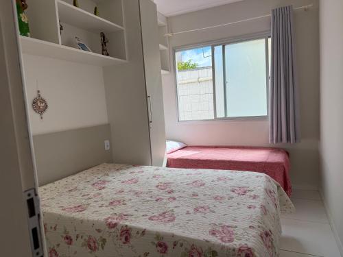 a small bedroom with a bed and a window at Apto 2 Quartos Perfeito in Guarapari