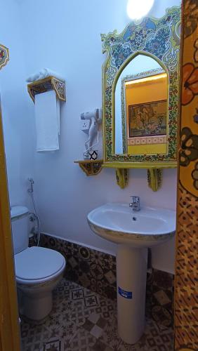 a bathroom with a sink and a toilet and a mirror at Riad Las mil y una noches 2 Tetuan in Tetouan