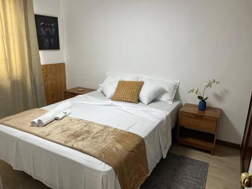 una camera da letto con un letto grande con lenzuola e cuscini bianchi di Plateau- Sea View Apartment a Praia