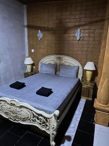 a bedroom with a large white bed with two lamps at Mahagedara Grand Villa in Nittambuwa