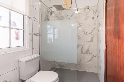 a white bathroom with a toilet and a shower at Apartments Vista Oceano in Funchal