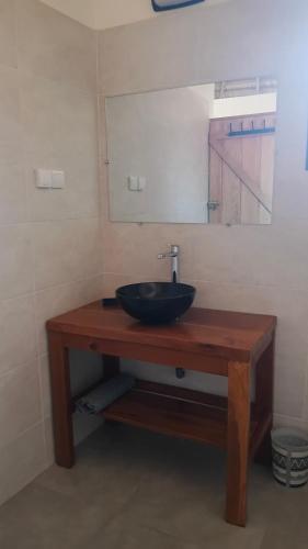 a bathroom with a sink and a mirror at JAMNAATI Campement in Mboro