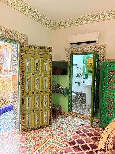a bathroom with two doors and a sink at Riad Las mil y una noches 2 Tetuan in Tetouan