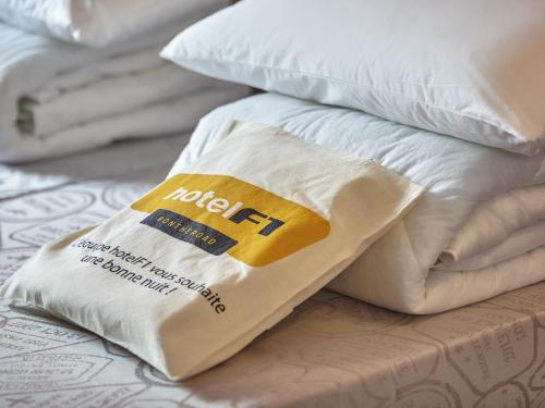 a pile of white pillows on top of a bed at hotelF1 La Rochelle Angoulins "Rénové" in Angoulins