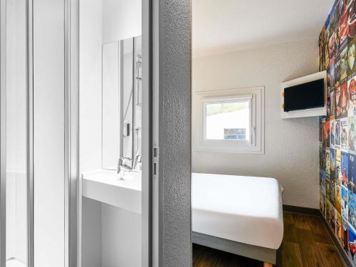 a bathroom with a white sink and a window at hotelF1 Rungis Orly in Rungis