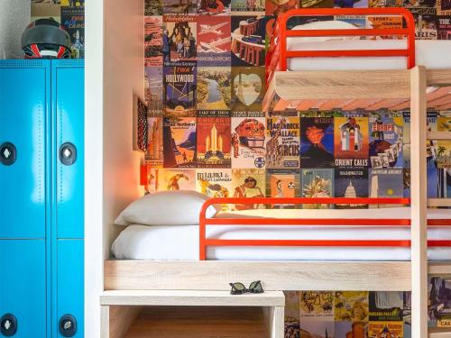 a bedroom with a bunk bed with a wall covered in posters at hotelF1 Chambéry Nord Rénové in Chambéry