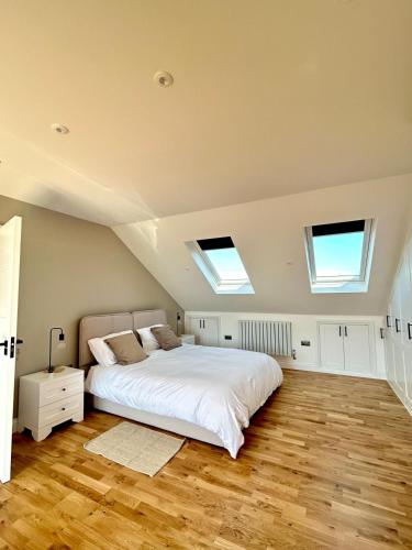 a bedroom with a bed and two skylights at The Crescent Villa Lancing in Lancing