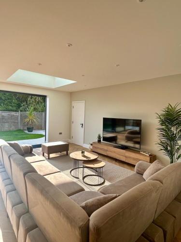 a large living room with a large couch and a flat screen tv at The Crescent Villa Lancing in Lancing