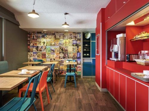 a restaurant with tables and chairs and red walls at hotelF1 Chartres in Le Coudray