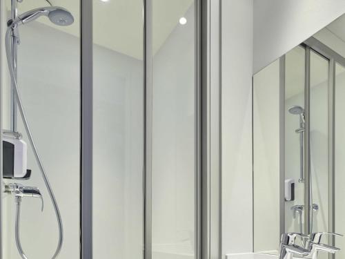 a bathroom with a shower with glass walls at hotelF1 Paris Saint Denis Université in Saint-Denis