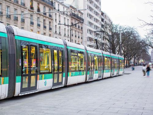 a train is parked on a city street at hotelF1 Paris Saint Denis Université in Saint-Denis
