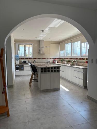 a large kitchen with an arch in the middle at Hermosa casa al pie del cerro in Salta
