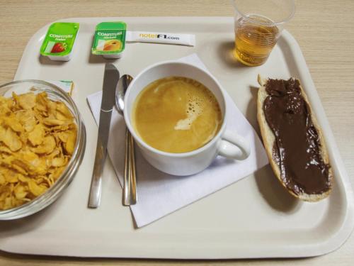 a tray with a cup of coffee and a sandwich at hotelF1 Grenoble Université in Gières
