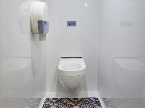 a bathroom with a toilet in a white wall at hotelF1 Toulouse Aéroport in Blagnac