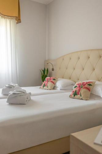 a bed with two pillows on top of it at Hotel Castello Artemide Congressi in Castel San Pietro Terme