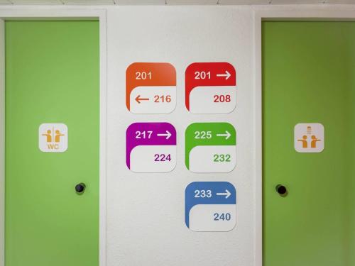 a door with different colored signs on a wall at hotelF1 Lille Villeneuve d'Ascq in Villeneuve d'Ascq