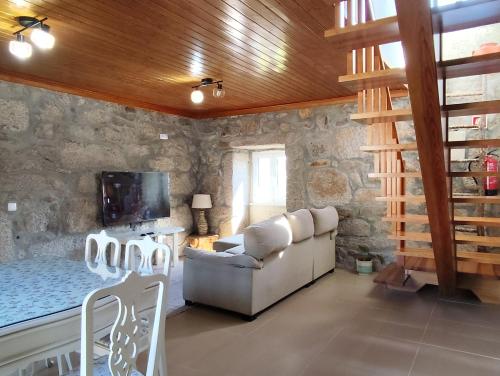 a living room with a couch and a tv at Oak House in São João do Monte