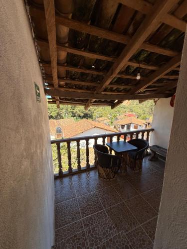 a porch with a table and chairs on a balcony at Hotel del Pozo in San Sebastián del Oeste