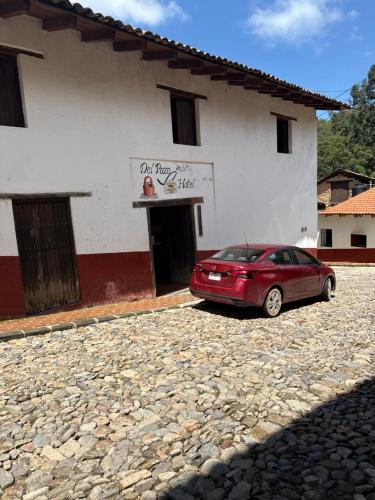 a red car parked in front of a building at Hotel del Pozo in San Sebastián del Oeste