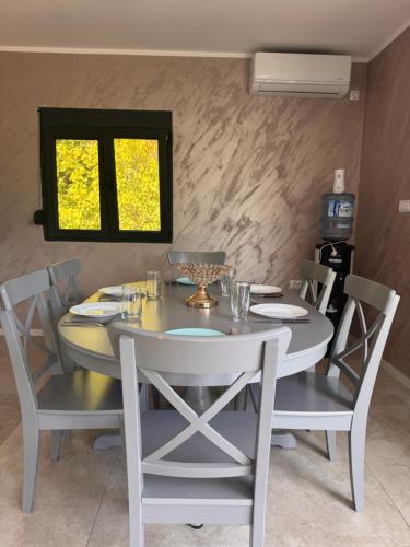 a dining room table and chairs with a white table and a window at Vila Sava with Pool & Jacuzzi and House Boat in Belgrade