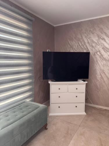 a living room with a tv and a white dresser at Vila Sava with Pool & Jacuzzi and House Boat in Belgrade