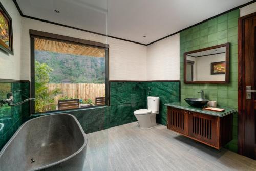 a bathroom with a tub and a sink and a toilet at The Greenary Garden in Xuân Sơn