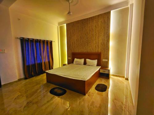 The Vindhya Stay - Your Countryside Escape的一间卧室，有一张床和一扇带蓝色窗帘的窗户