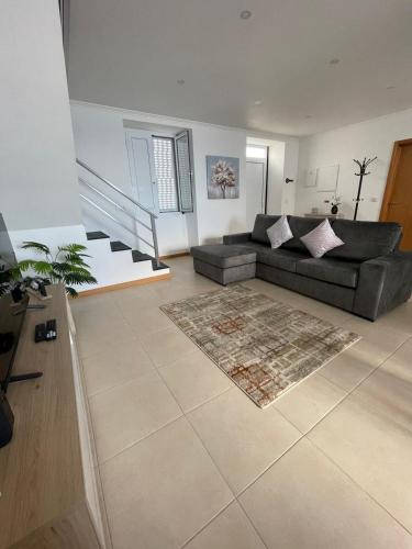a living room with a couch and a rug at Casa Dona Rosa in Ponta Delgada