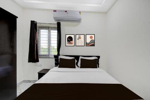 a bedroom with a white bed and two pictures on the wall at Hotel O Bright Inn near TCS in Hyderabad