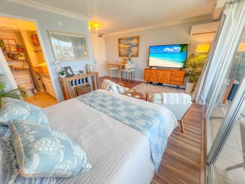 a bedroom with a bed and a flat screen tv at Honu Hideaway Studio at Royal Garden in Honolulu