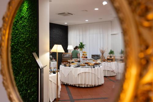 a group of tables with food on them in a room at Hotel Castello Artemide Congressi in Castel San Pietro Terme