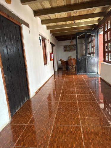 an empty room with a wooden door and a tile floor at Hotel del Pozo in San Sebastián del Oeste