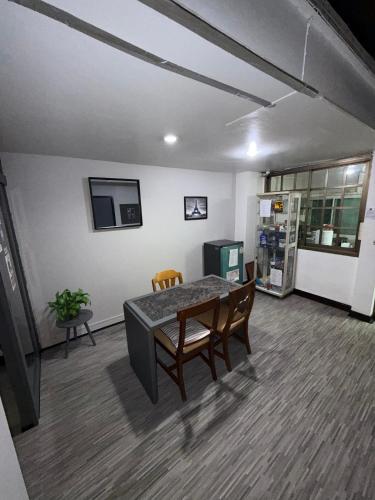 a room with a table and chairs and a refrigerator at Ree House- Sukhumvit 23 in Bangkok